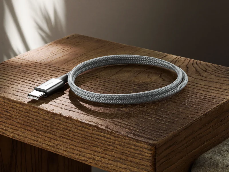 Geflochtenes USB-C-Kabel locker aufgerollt auf einem Eichenbrett